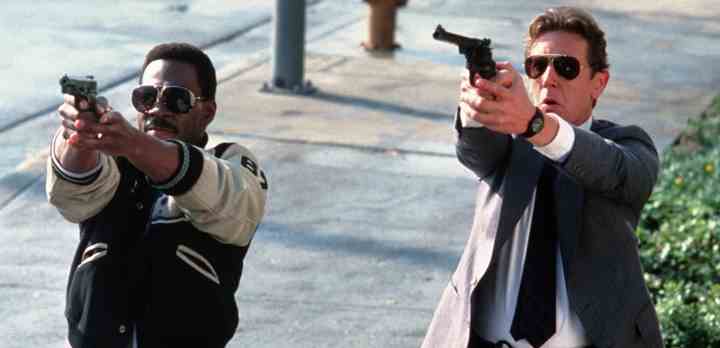 Eddie Murphy som den uortodokse og rapkærtede politimand Axel Foley og Judge Reinhold som Beverly Hills-strømeren Billy Rosewood som i Tony Scotts hæsblæsende krimi-komedie"Frækkere end politiet tillader 2" fra 1987. Som skurk i filmen ses ingen ringere end danske Birgitte Nielsen (Foto: TV 2)