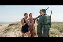 Grosserer Madsen (Lars Ranthe) og fru Therese (Anne Louise Hassing) møder to tyske soldater på stranden. 