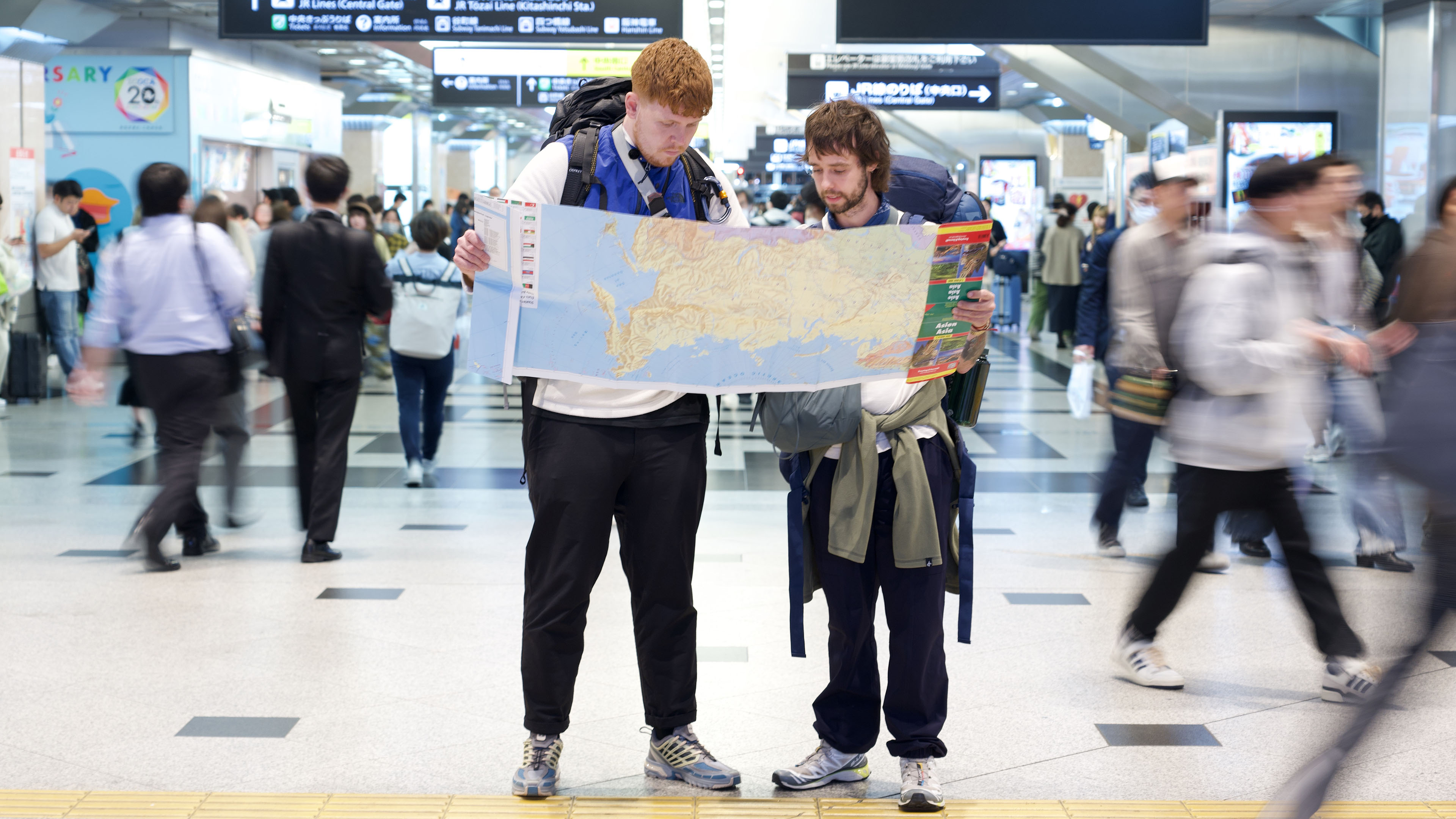 Martin og Sebastian fra Grønt hold kigger på kort i Tokyos undergrundsbane. 